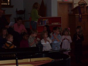 Sorry the picture is so dark... the camera just doesn't like the sanctuary. Here they are practicing their song. Gavin is on the left! 